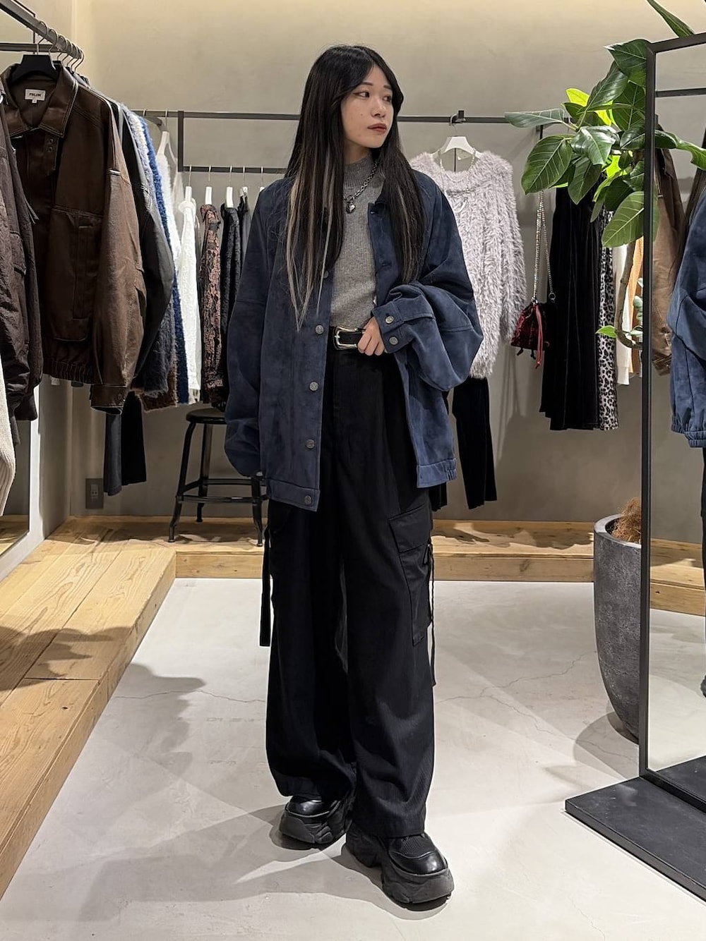 ブラック系のブーツ、ブラック系のスラックス、ブルー系のブルゾンを着用したレディースの冬コーディネートの1枚目の写真