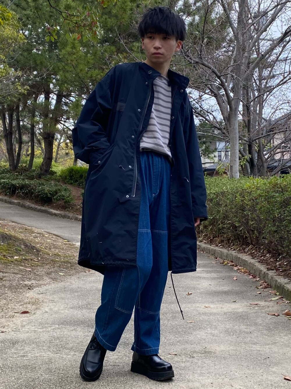 ブルー系のモッズコート、グレー系のTシャツ/カットソー、ブルー系のデニムパンツを着用したメンズの春コーディネートの1枚目の写真