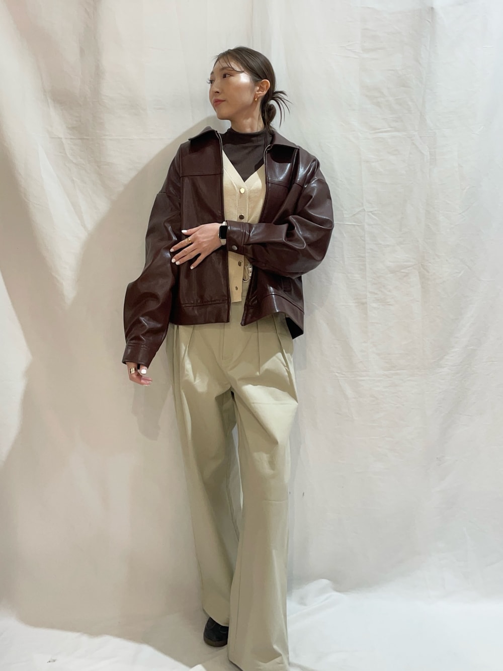 ホワイト系のニット/セーター、ベージュ系のその他パンツ、ブラウン系のブルゾンを着用したレディースの春コーディネートの1枚目の写真