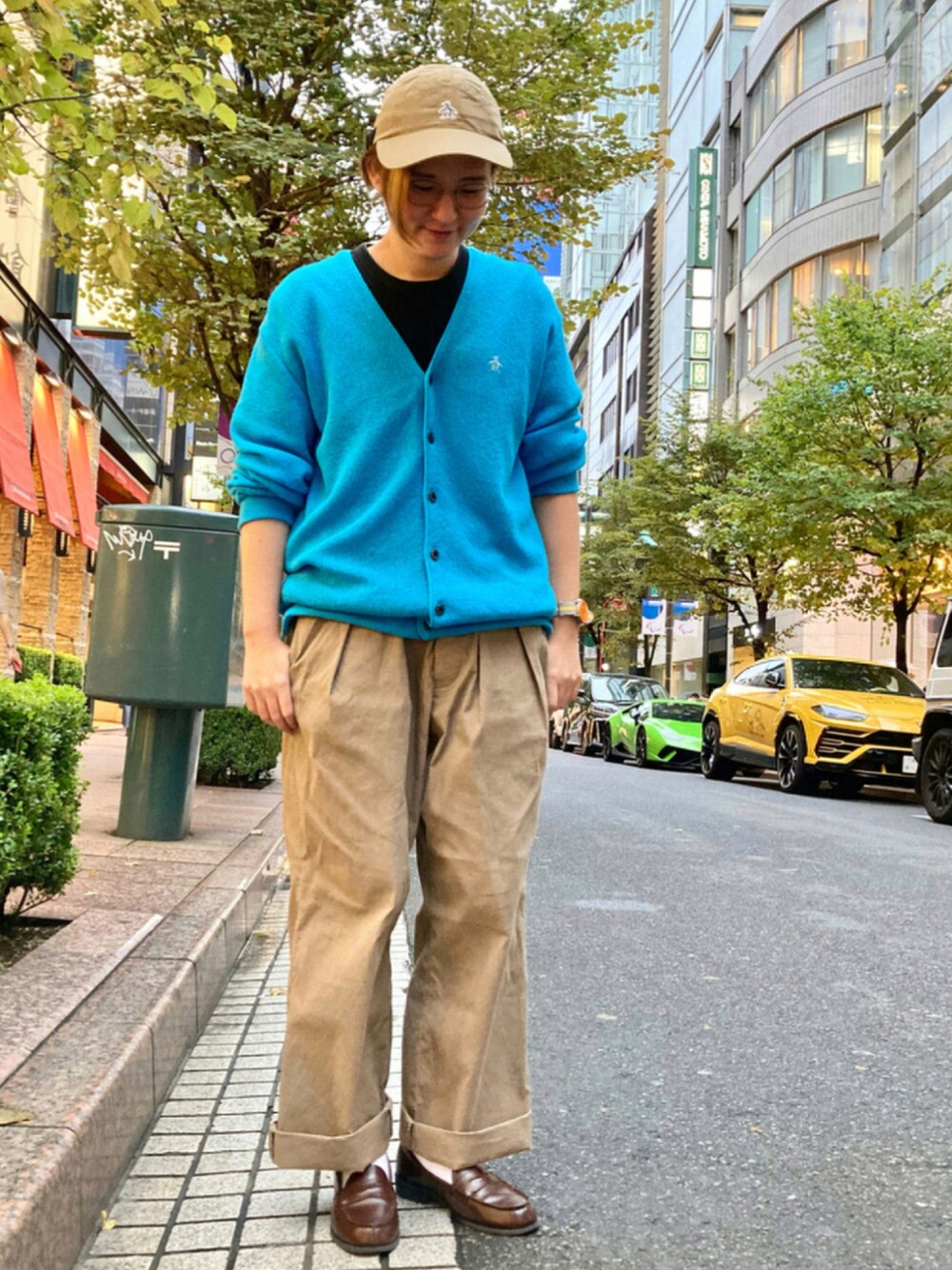 ブラウン系のスラックス、ブルー系のカーディガン/ボレロ、ベージュ系のキャップを着用したレディースの秋コーディネートの1枚目の写真