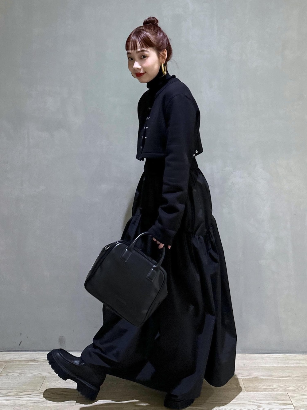 ブラック系のボストンバッグ、ブラック系のブーツ、ブラック系のカーディガン/ボレロを着用したレディースの秋コーディネートの1枚目の写真
