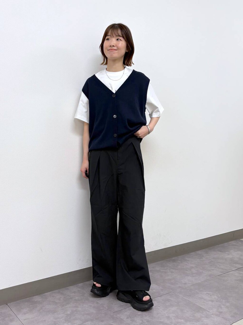 ホワイト系のTシャツ/カットソー、ブラック系のサンダル、ブラック系のカーゴパンツを着用したレディースの春コーディネートの1枚目の写真