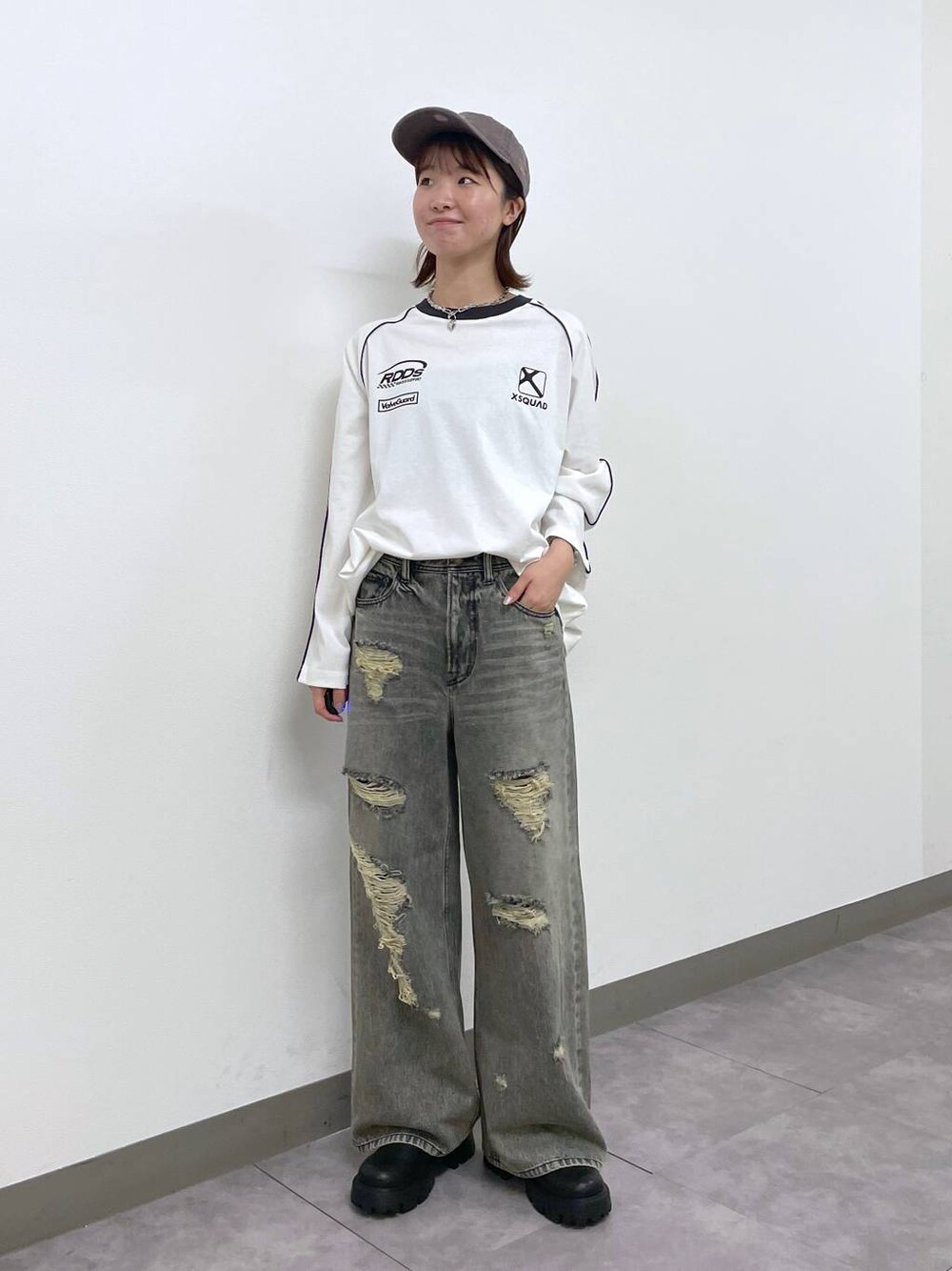 ブラック系のデニムパンツ、ブラック系のブーツ、ホワイト系のTシャツ/カットソーを着用したレディースの秋コーディネートの1枚目の写真