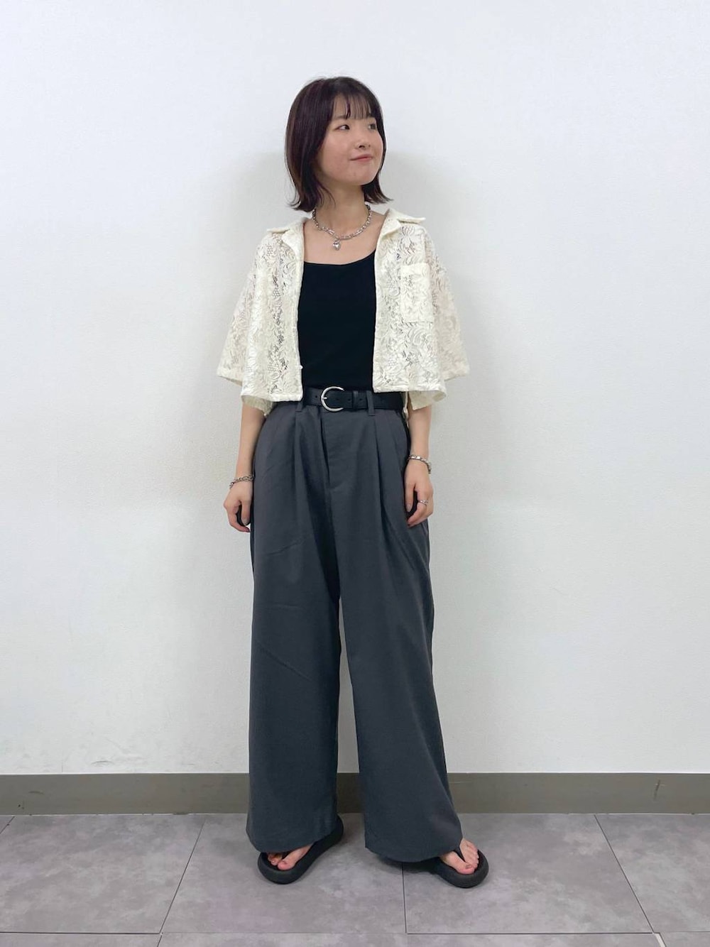 グレー系のスラックス、ホワイト系のシャツ/ブラウス、シルバー系のブレスレットを着用したレディースの夏コーディネートの1枚目の写真