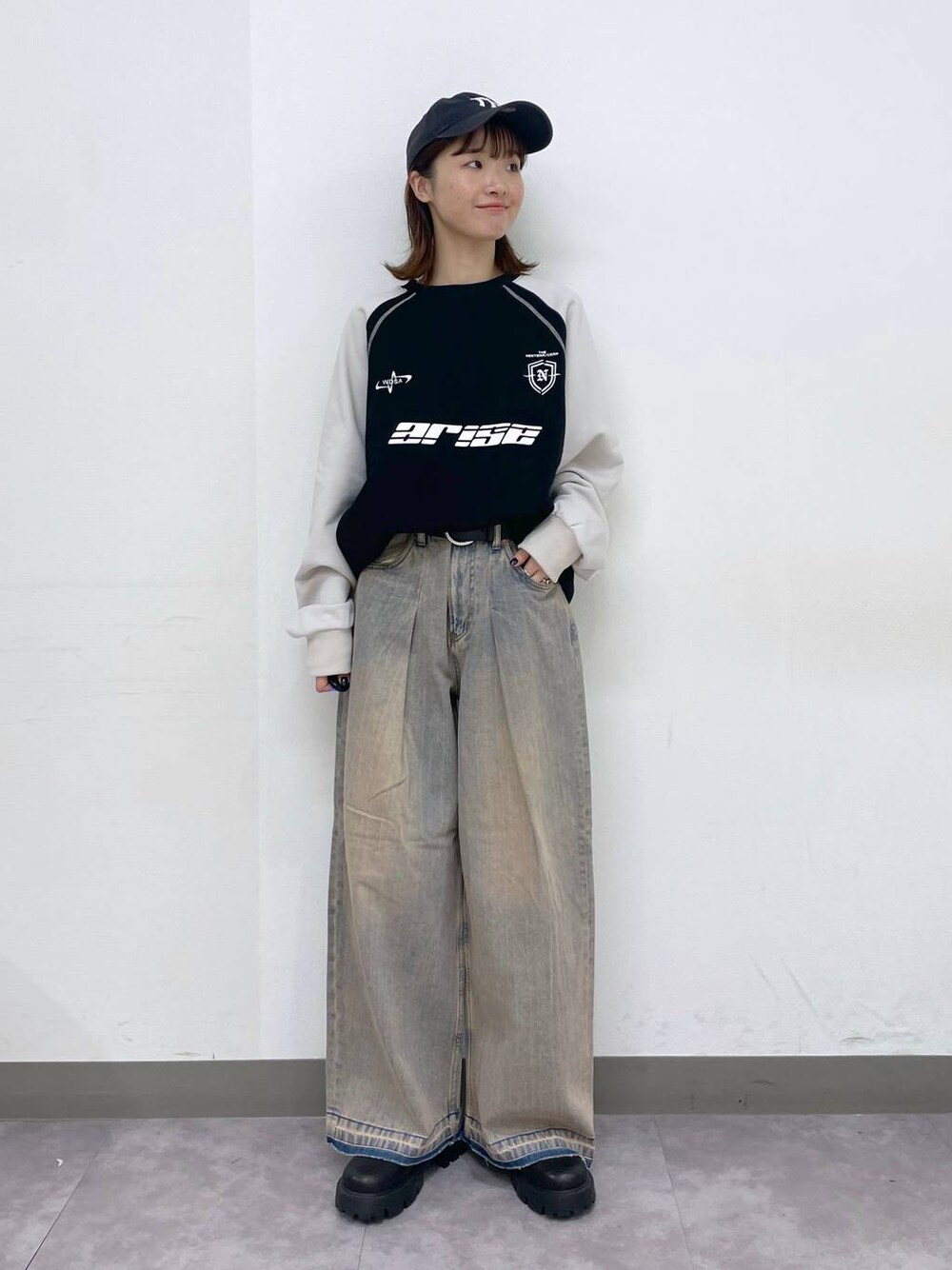 ブラック系のブーツ、ブラック系のスウェット、ブルー系のデニムパンツを着用したレディースの冬コーディネートの1枚目の写真