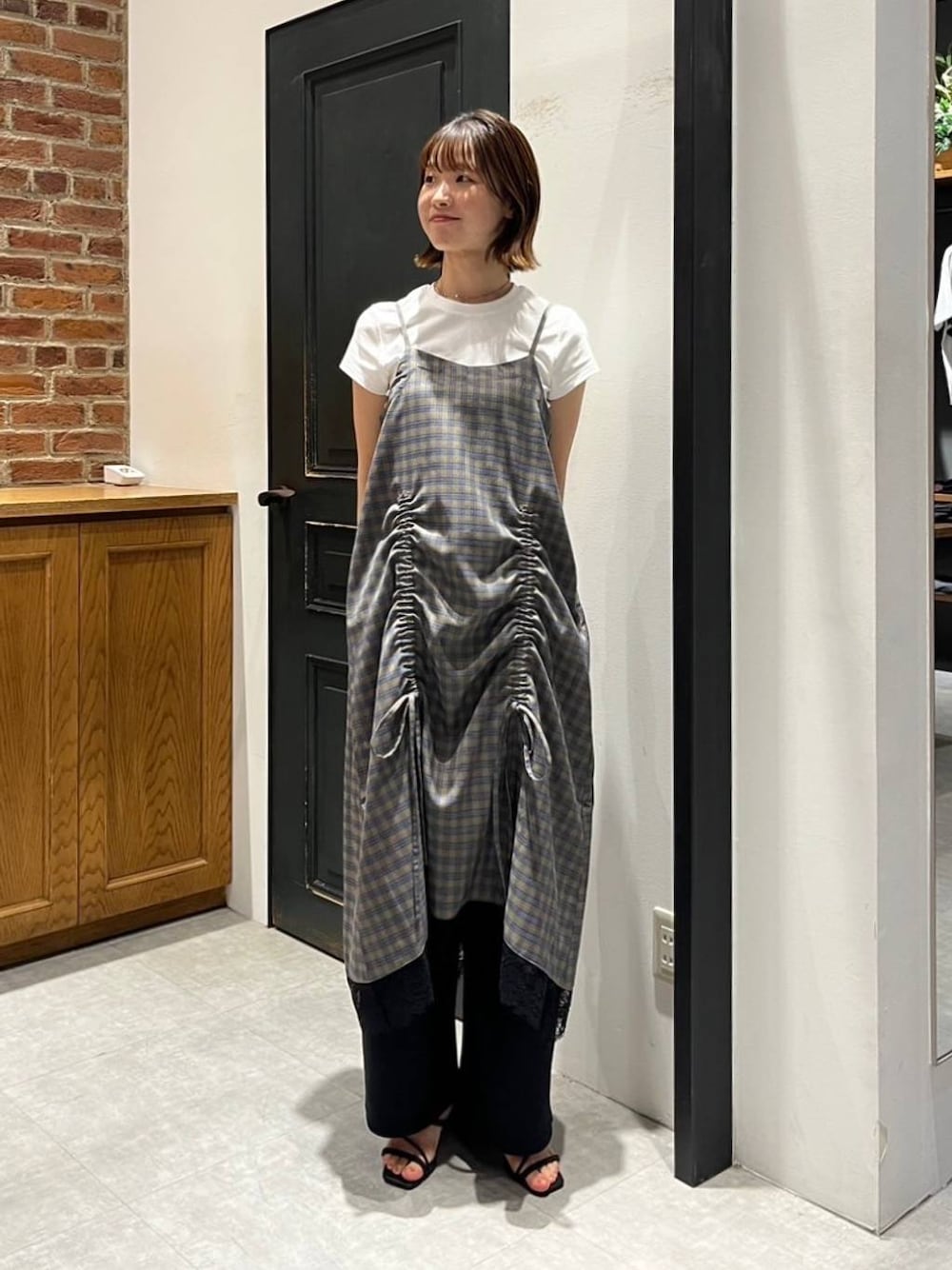 ブラック系のサンダル、ブラック系のスウェットパンツ、イエロー系のワンピースを着用したレディースの夏コーディネートの1枚目の写真