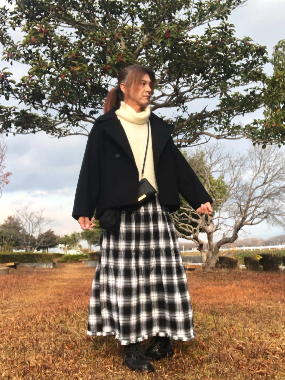 ホワイト系のスカート、ブラック系のブーツ、ブラック系のジャケット/アウターを着用したメンズの冬コーディネートの1枚目の写真