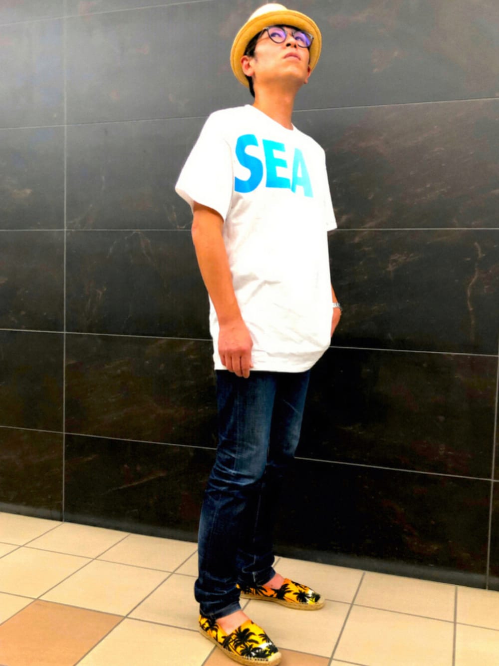 ホワイト系のTシャツ/カットソー、ブルー系のデニムパンツ、その他のスリッポンを着用したメンズの夏コーディネートの1枚目の写真