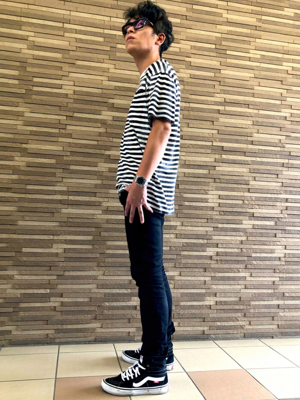 ブラック系のデニムパンツ、ブラック系のTシャツ/カットソー、ブラック系のスニーカーを着用したメンズの夏コーディネートの1枚目の写真