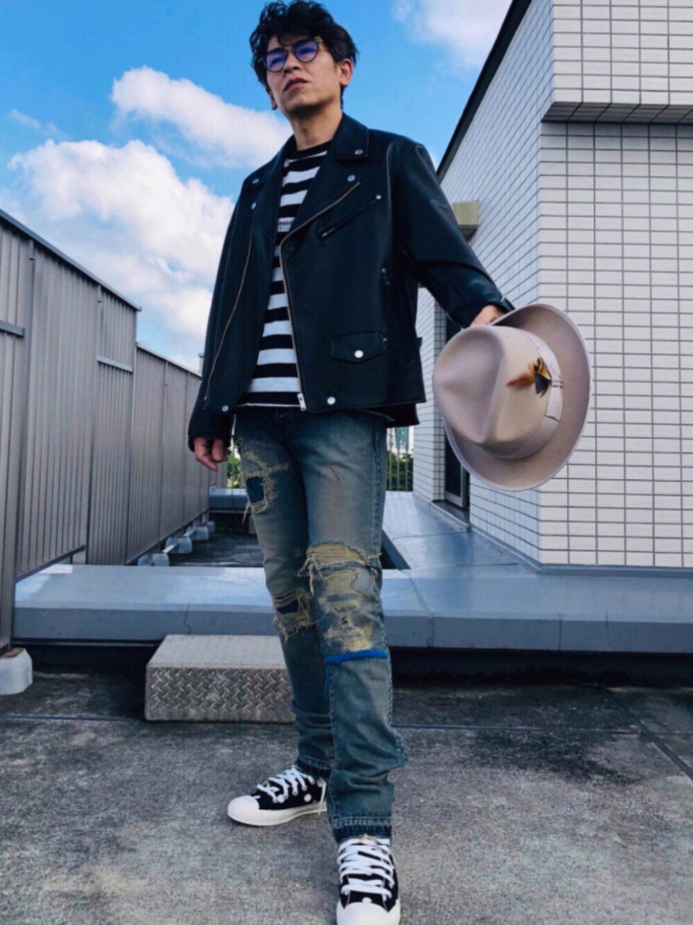 ブルー系のデニムパンツ、ブラック系のその他アウター、ブラック系のスニーカーを着用したメンズの秋コーディネートの1枚目の写真