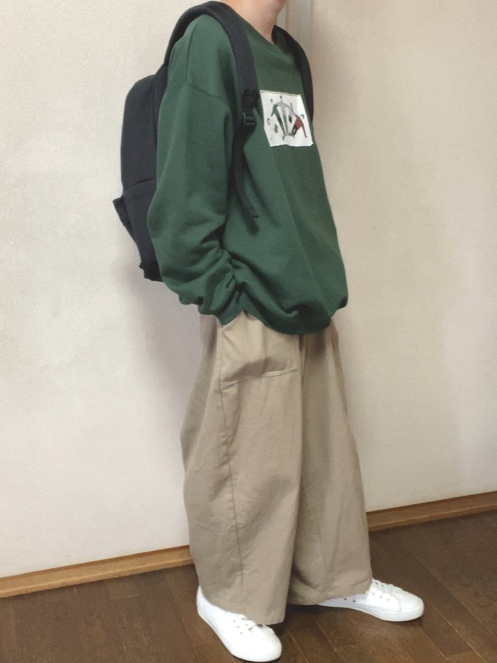 グリーン系のスウェット、ベージュ系のチノパンツを着用したメンズの秋コーディネートの1枚目の写真