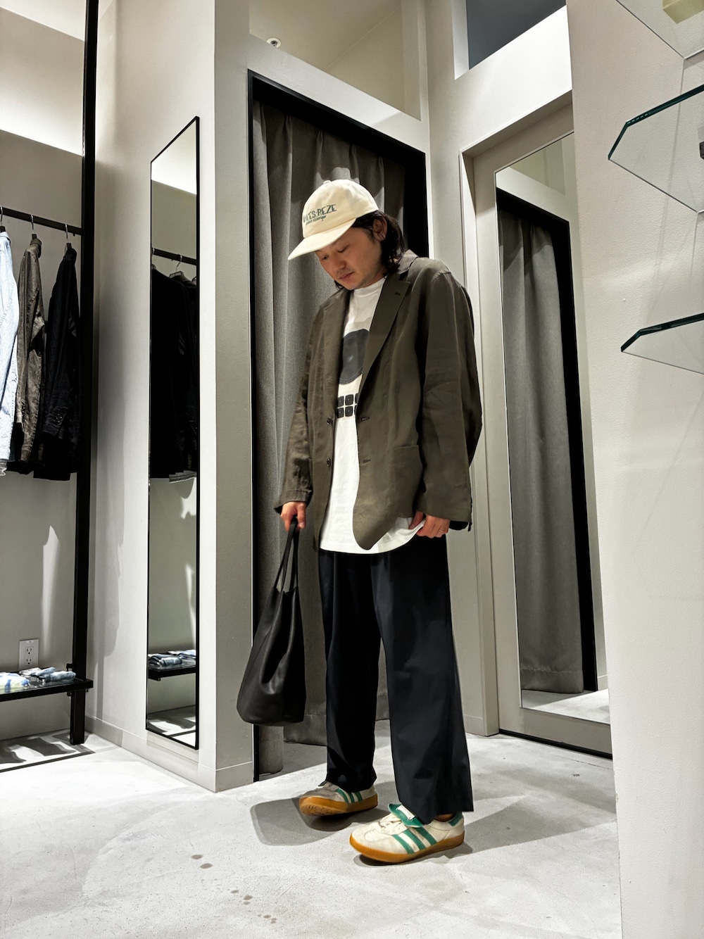 グレー系のトートバッグ、ホワイト系のTシャツ/カットソー、ブラウン系のテーラードジャケットを着用したメンズの夏コーディネートの1枚目の写真