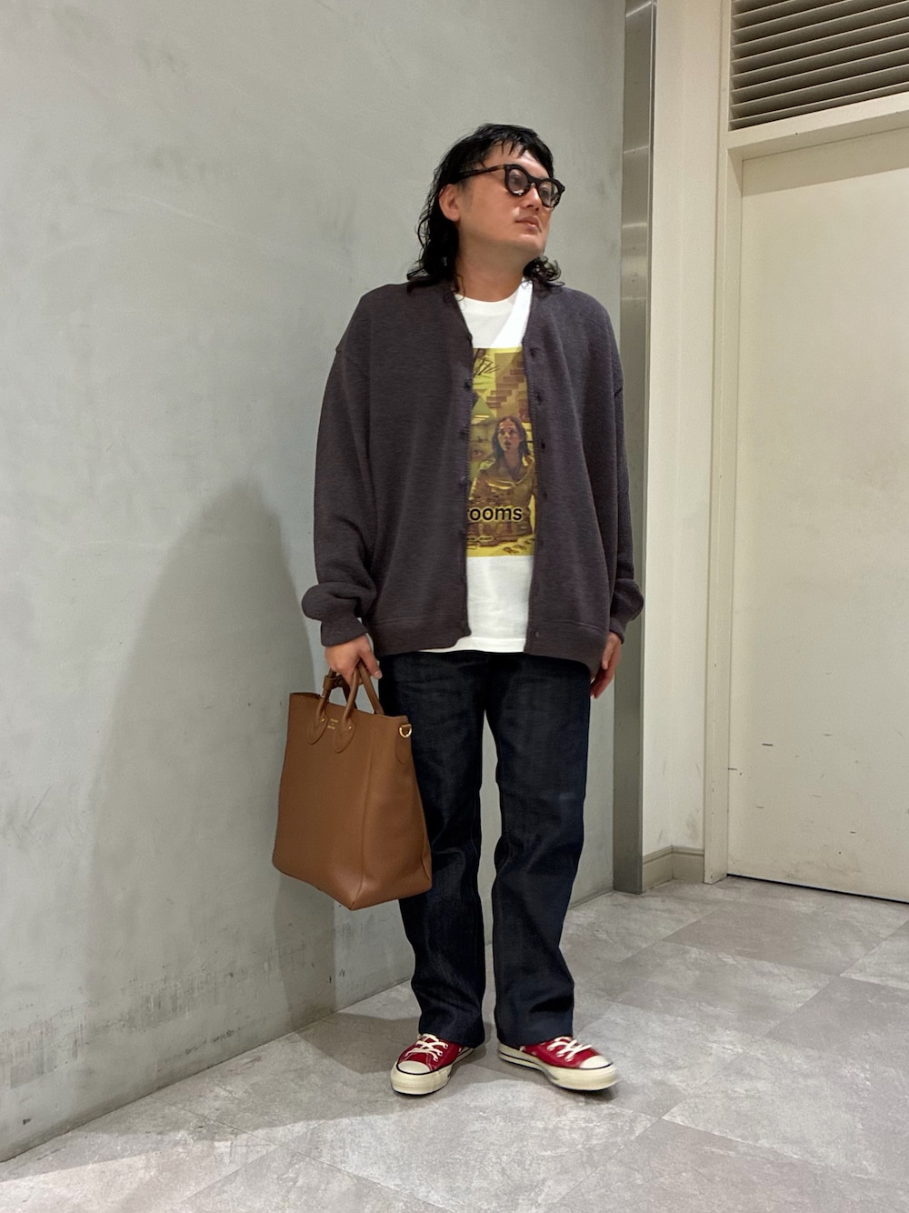 ブラウン系のカーディガン/ボレロ、ブルー系のデニムパンツ、ブラウン系のトートバッグを着用したメンズの秋コーディネートの1枚目の写真
