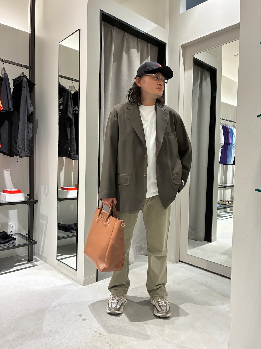 ブラウン系のテーラードジャケット、ベージュ系のデニムパンツ、ブラウン系のトートバッグを着用したメンズの夏コーディネートの1枚目の写真
