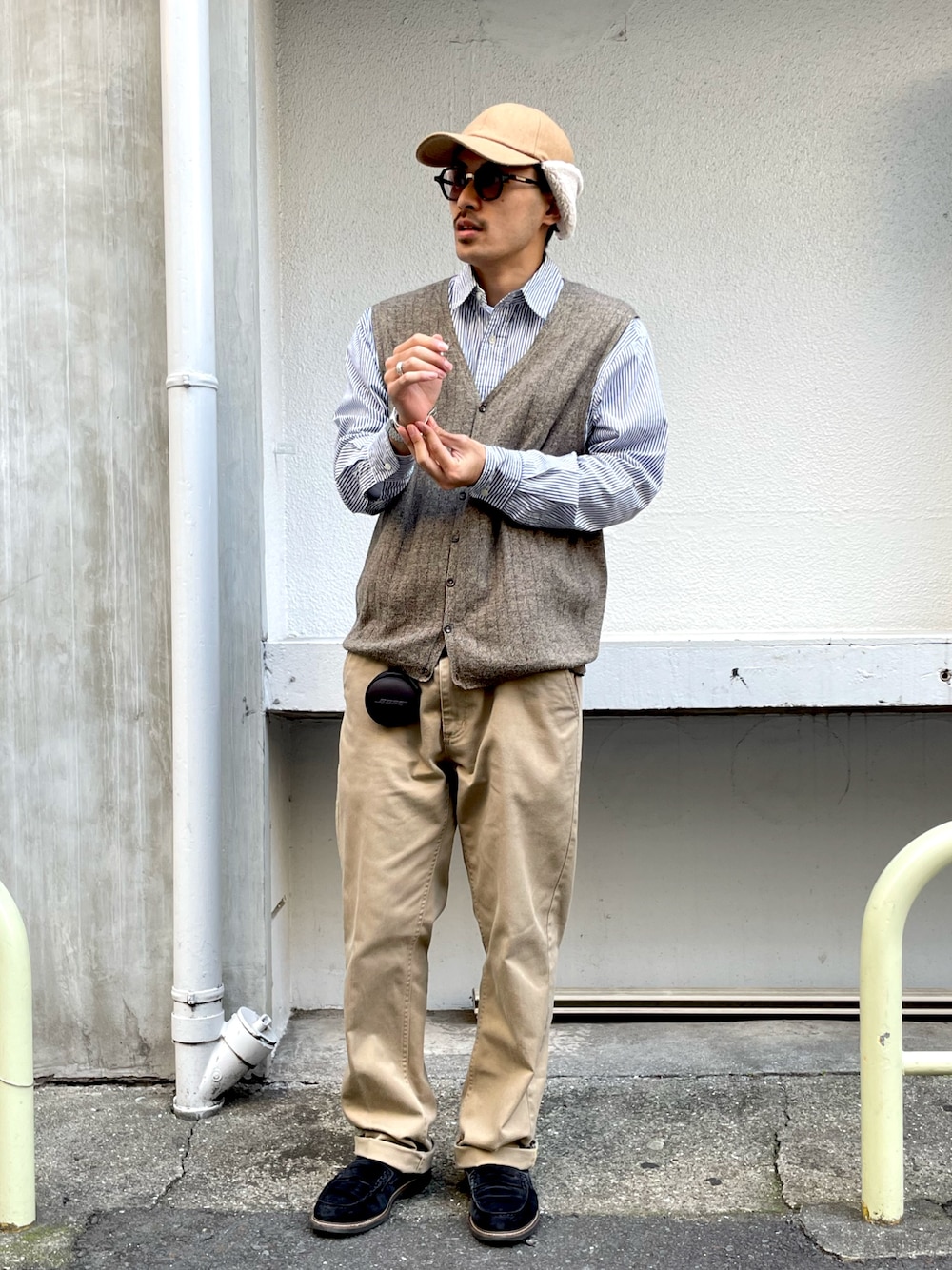 ベージュ系のベスト、ブルー系のシャツ/ブラウス、ベージュ系のチノパンツを着用したメンズの冬コーディネートの1枚目の写真