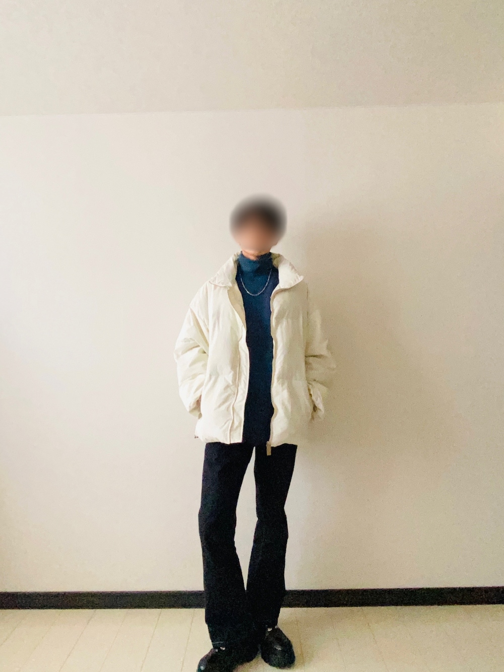 ホワイト系のダウンジャケット/コート、グリーン系のニット/セーター、ブルー系のデニムパンツを着用したメンズの冬コーディネートの1枚目の写真