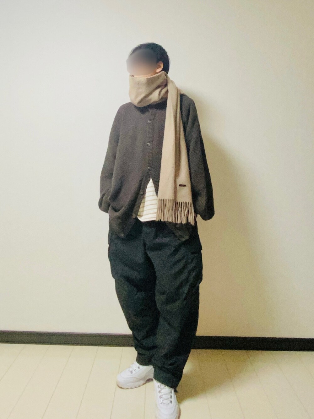 ブラウン系のカーディガン/ボレロ、ベージュ系のTシャツ/カットソー、ブラック系のカーゴパンツを着用したメンズの冬コーディネートの1枚目の写真