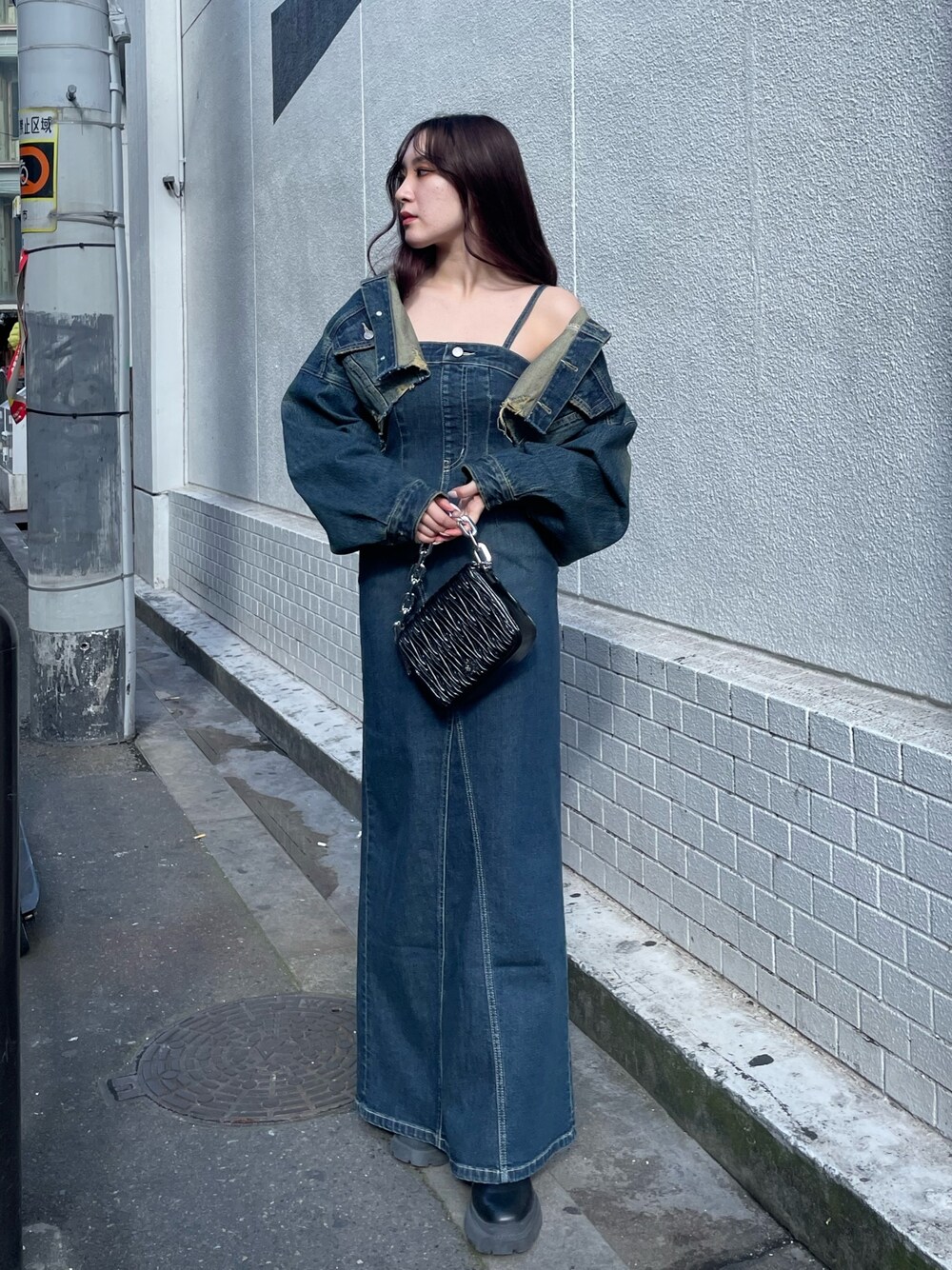 ブラック系のショルダーバッグ、ブルー系のワンピース、ブルー系のデニムジャケットを着用したレディースの冬コーディネートの1枚目の写真