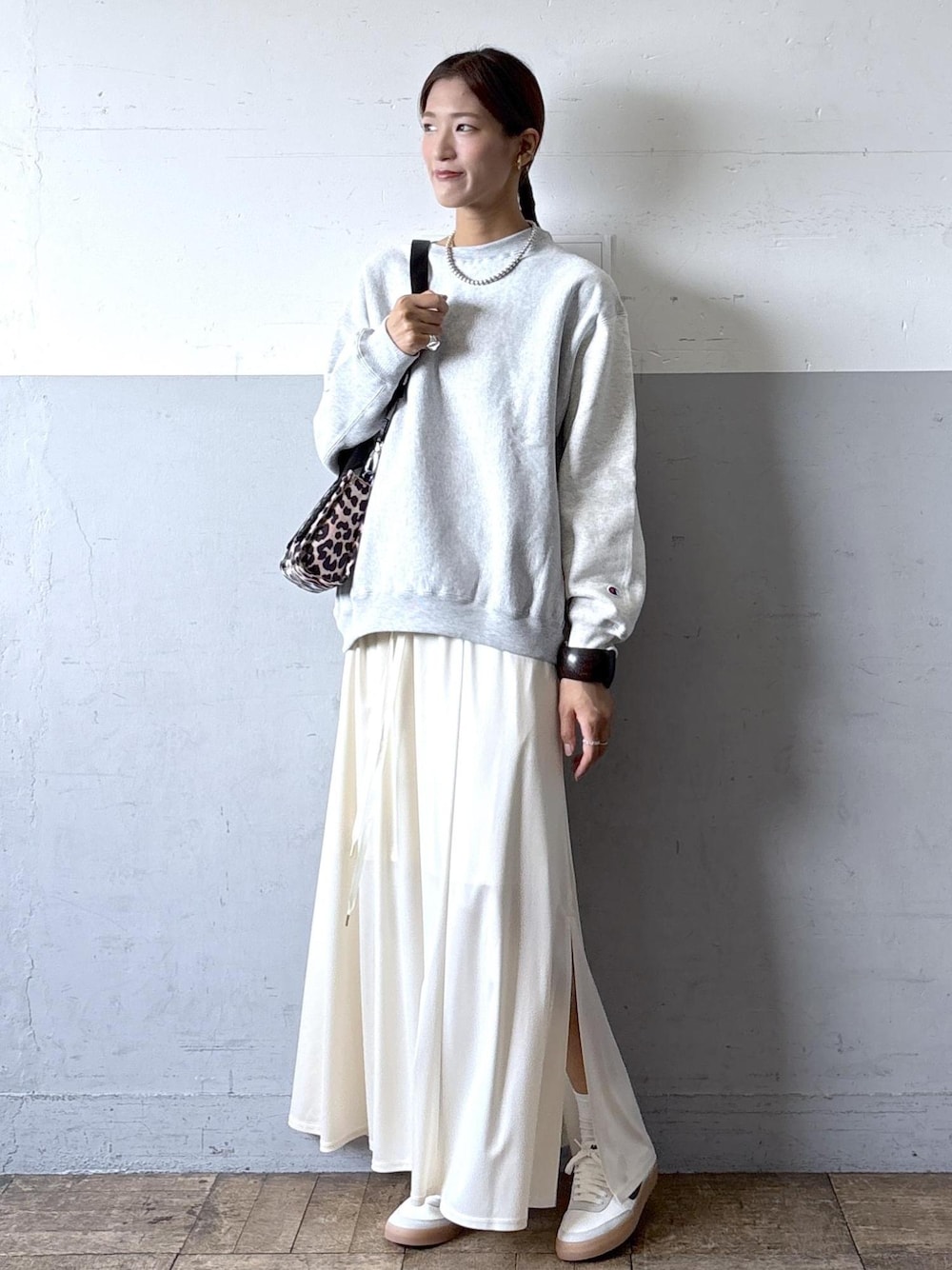 ベージュ系のショルダーバッグ、ホワイト系のスニーカー、ホワイト系のスカートを着用したレディースの秋コーディネートの1枚目の写真