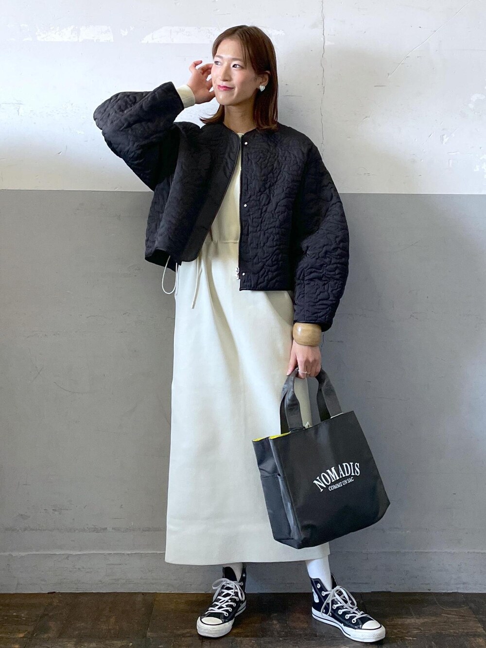ホワイト系のワンピース、ブラック系のブルゾン、グレー系のハンドバッグを着用したレディースの冬コーディネートの1枚目の写真