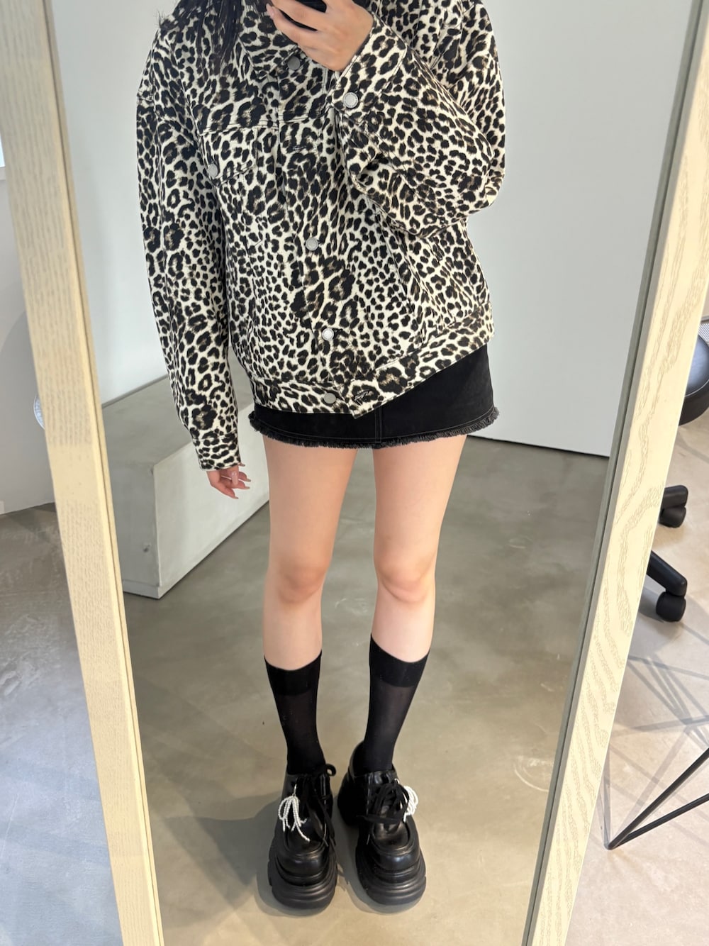 ホワイト系のブルゾン、ブラック系のスカート、ブラック系のローファーを着用したレディースの秋コーディネートの1枚目の写真