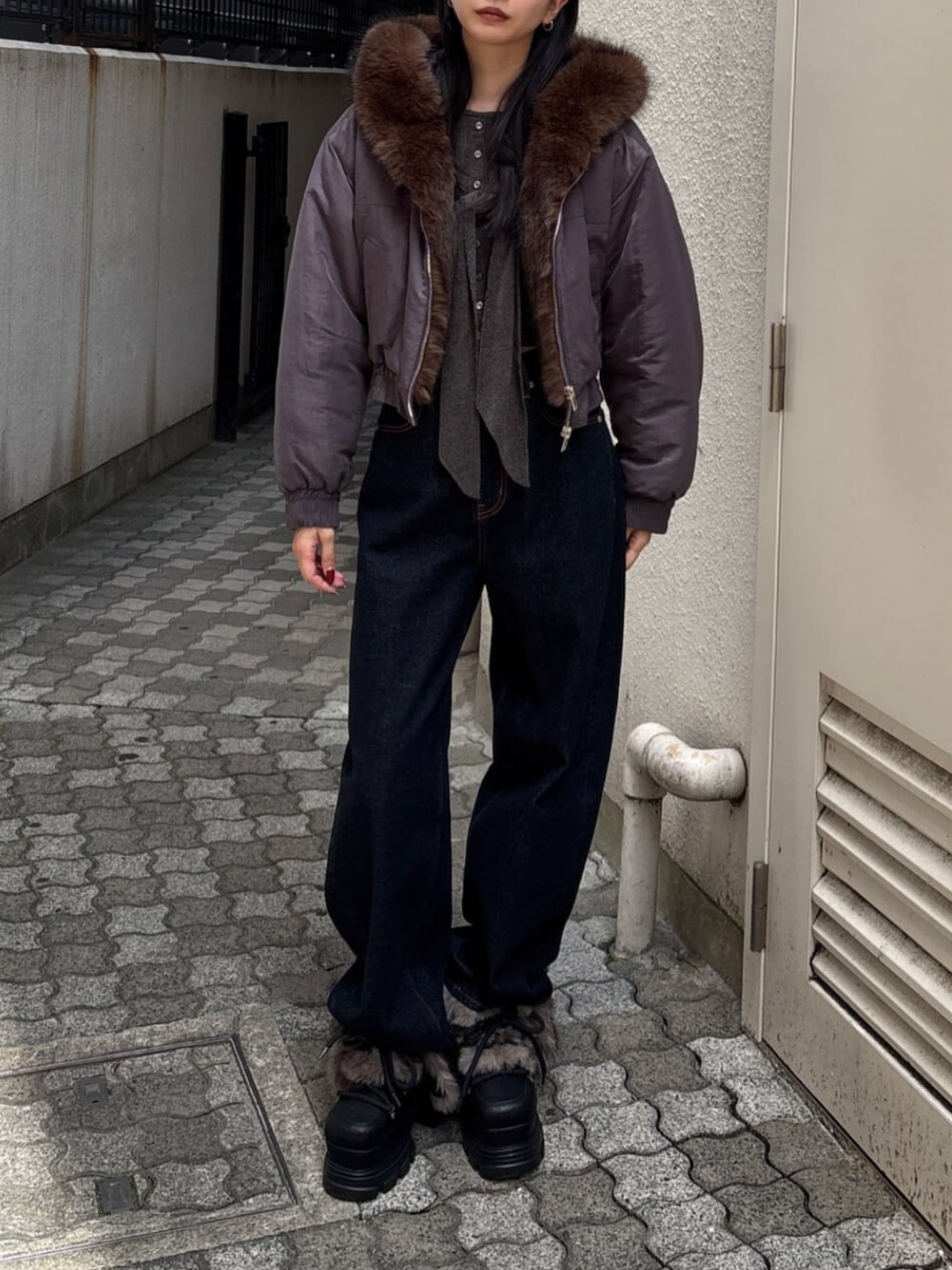 ブルー系のデニムパンツ、グレー系のブルゾン、ブラック系のブーツを着用したレディースの秋コーディネートの1枚目の写真