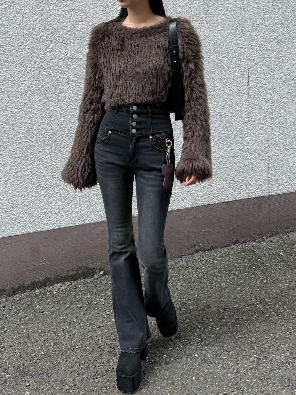 ブラック系のデニムパンツ、ブラウン系のニット/セーターを着用したレディースの冬コーディネートの1枚目の写真