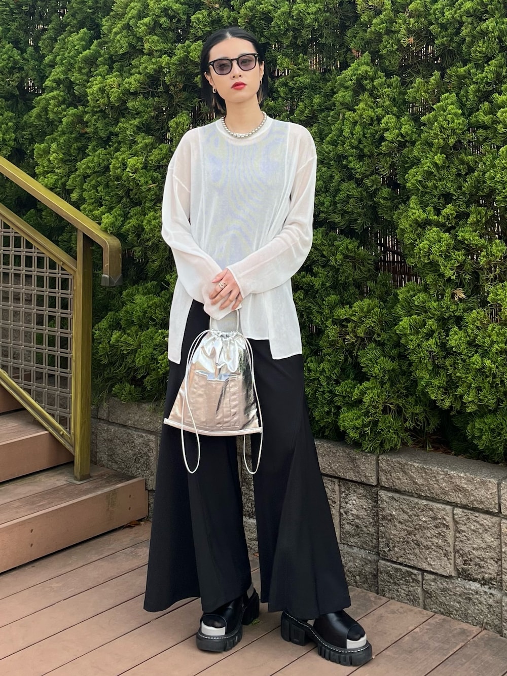 ホワイト系のニット/セーター、ブラック系のその他パンツ、シルバー系のショルダーバッグを着用したレディースの春コーディネートの1枚目の写真