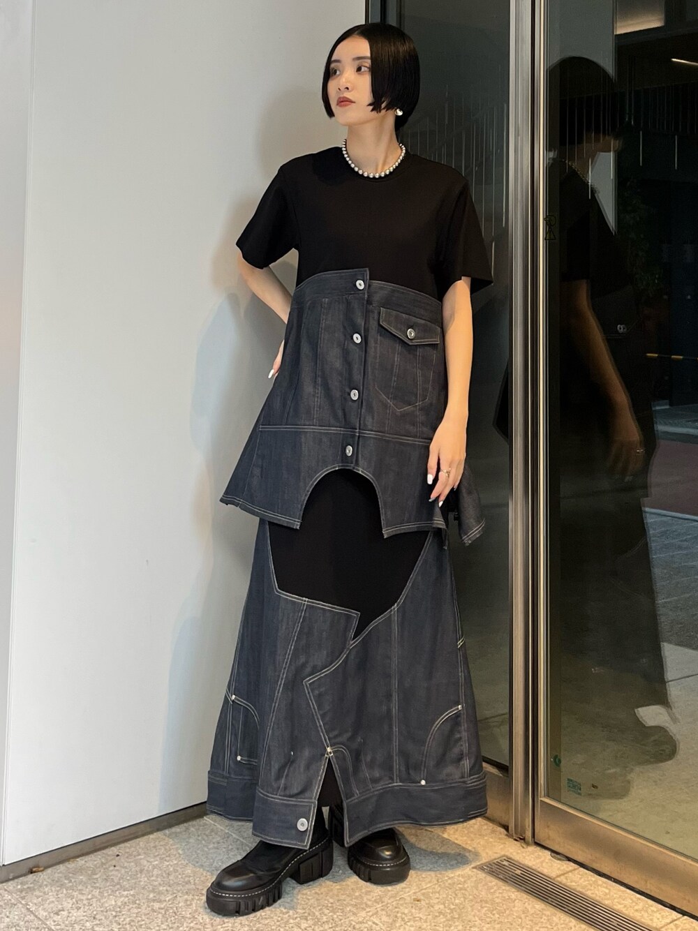 ブルー系のスカート、ブルー系のTシャツ/カットソー、ブラック系のブーツを着用したレディースの冬コーディネートの1枚目の写真