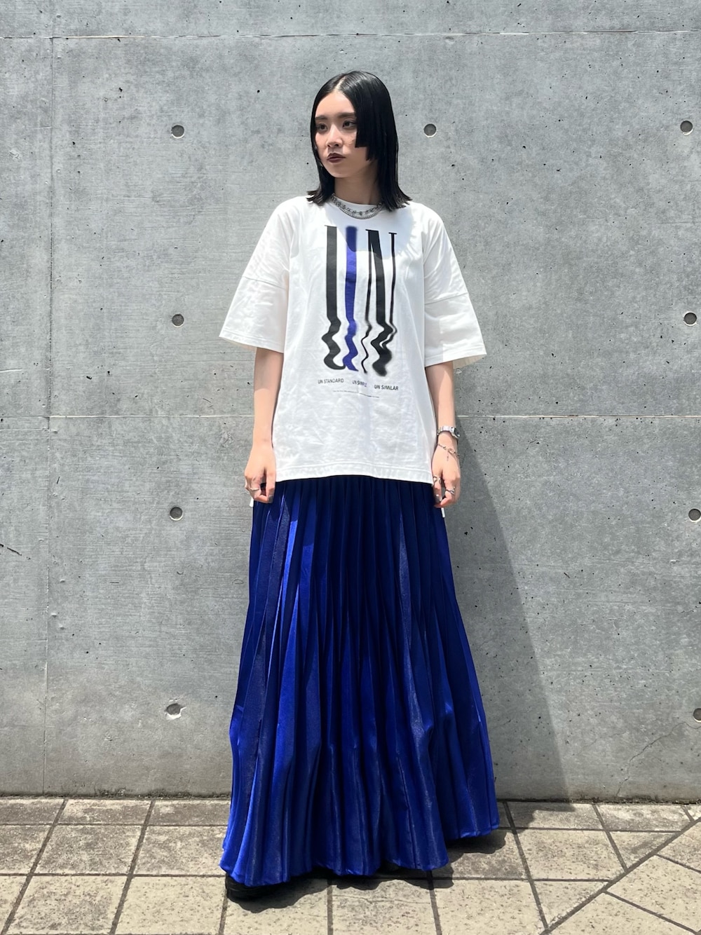 ホワイト系のTシャツ/カットソー、ブルー系のスカート、ブラック系のスニーカーを着用したレディースの夏コーディネートの1枚目の写真