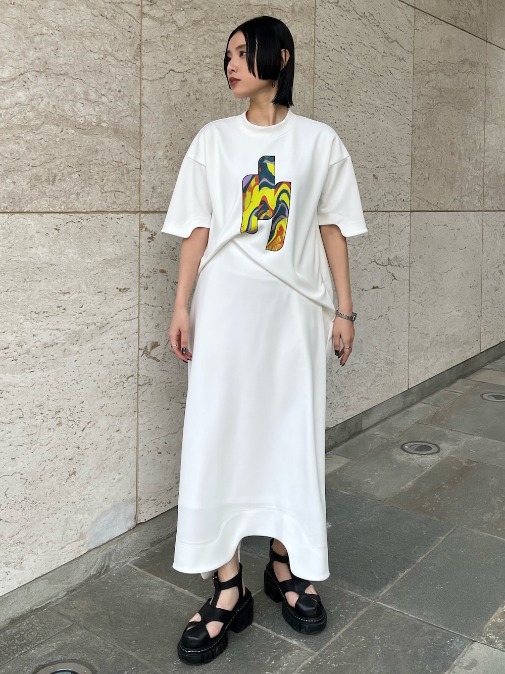 ホワイト系のワンピース、ブラック系のサンダル、ブラック系のイヤリングを着用したレディースの冬コーディネートの1枚目の写真