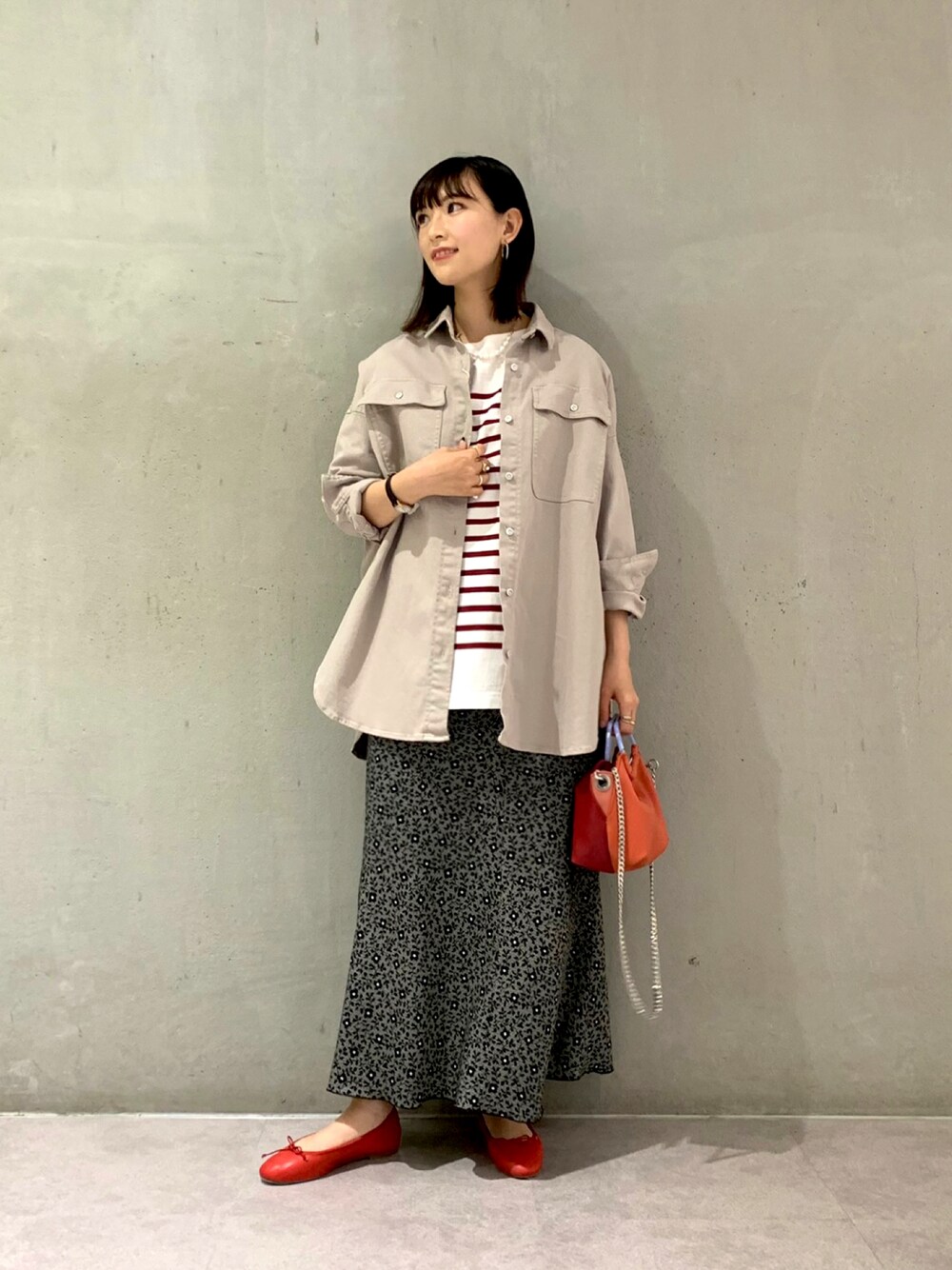 レッド系のTシャツ/カットソー、ベージュ系のデニムジャケット、レッド系のハンドバッグを着用したレディースの冬コーディネートの1枚目の写真