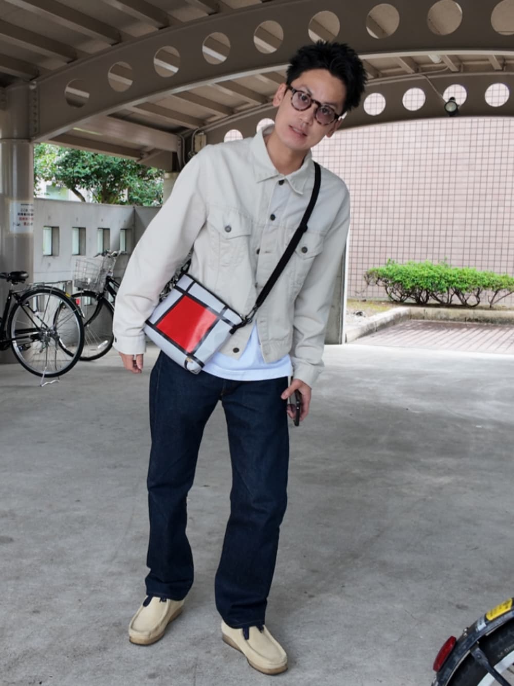 ブルー系のデニムパンツ、ベージュ系のブーツ、ホワイト系のTシャツ/カットソーを着用したメンズの秋コーディネートの1枚目の写真