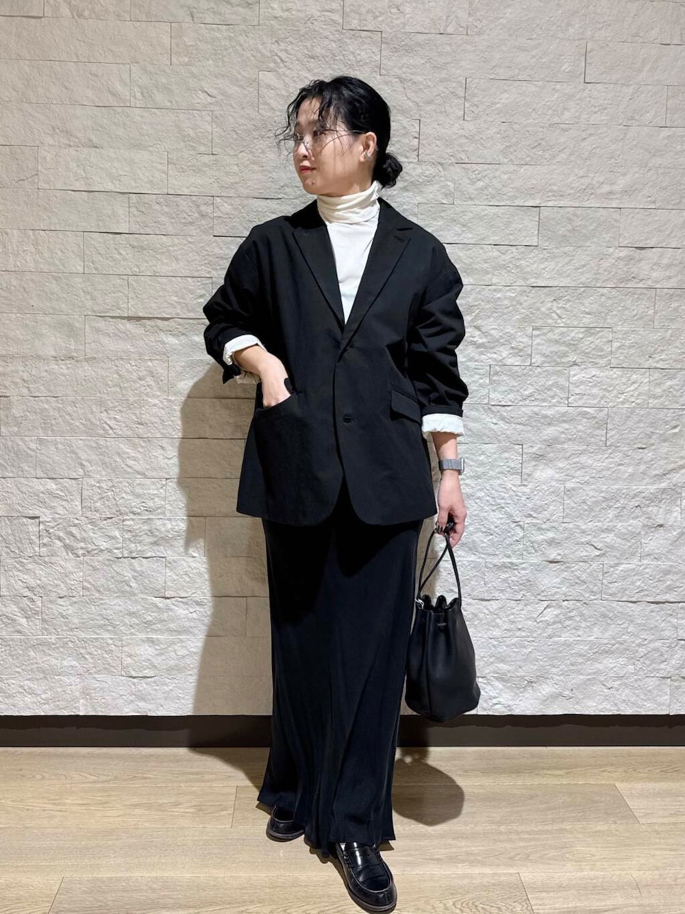 ホワイト系のTシャツ/カットソー、ブラック系のスカートを着用したレディースの冬コーディネートの1枚目の写真