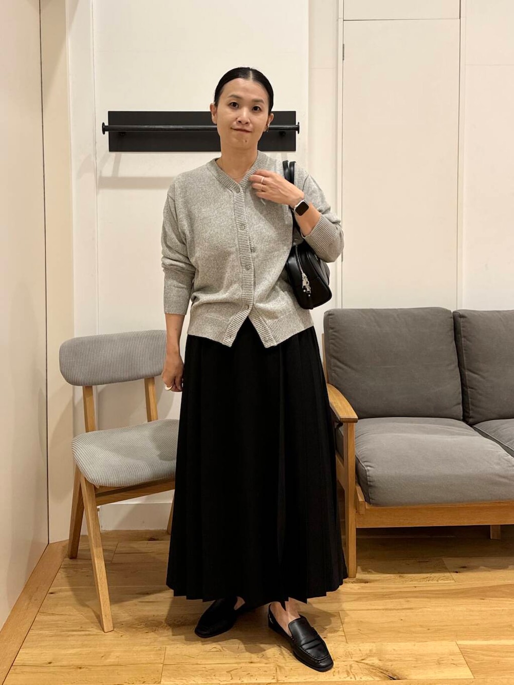 ブラック系のスカート、ブラック系のサンダル、ブラック系のボストンバッグを着用したレディースの夏コーディネートの1枚目の写真