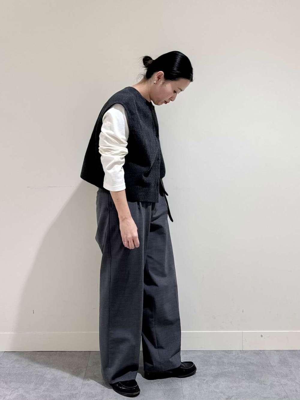 グレー系のピーコート、グレー系のその他パンツ、ホワイト系のTシャツ/カットソーを着用したレディースの冬コーディネートの1枚目の写真