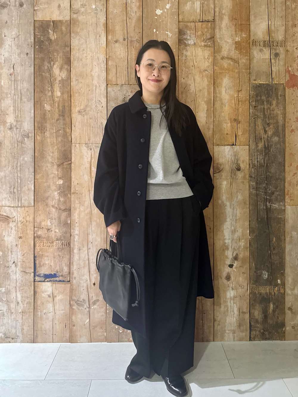 ブルー系のステンカラーコート、グレー系のTシャツ/カットソー、ブラック系のその他パンツを着用したレディースの冬コーディネートの1枚目の写真