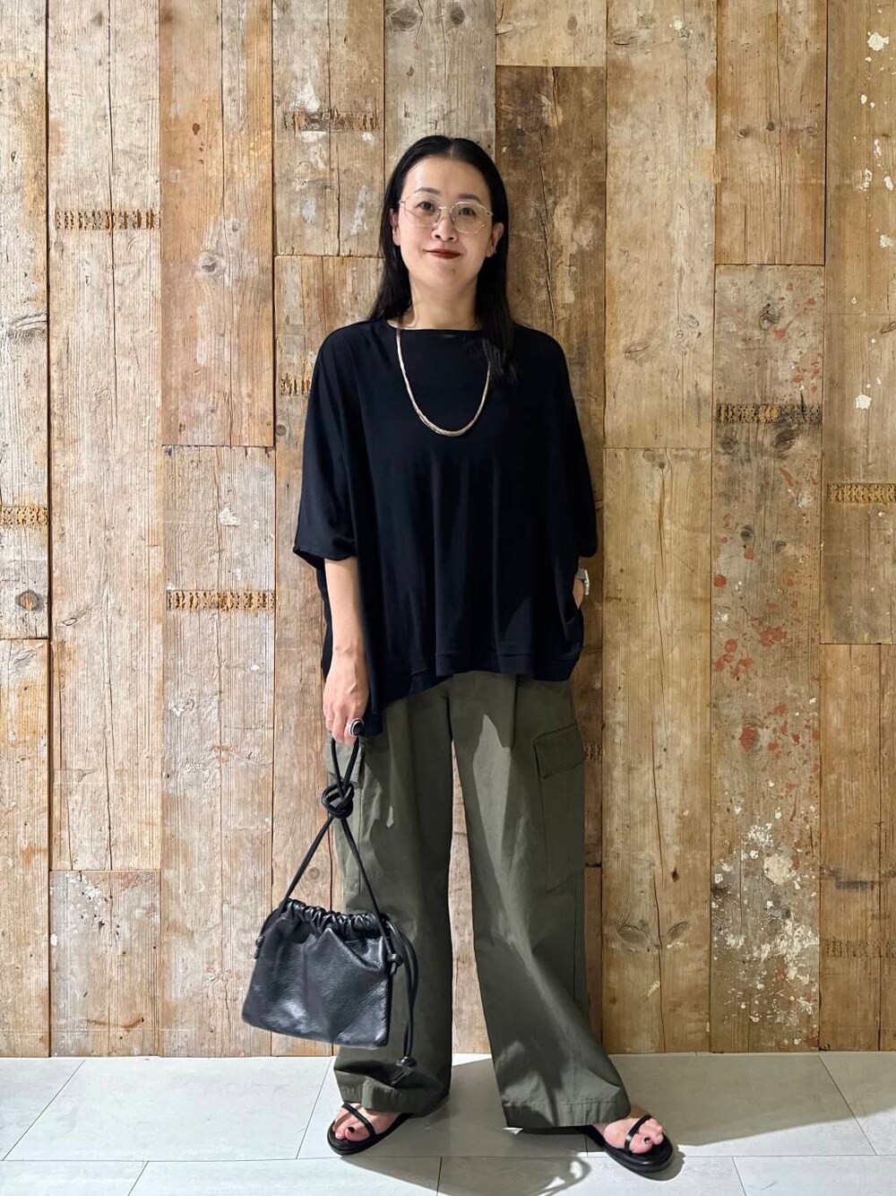 グリーン系のその他パンツ、ブラック系のTシャツ/カットソーを着用したレディースの夏コーディネートの1枚目の写真