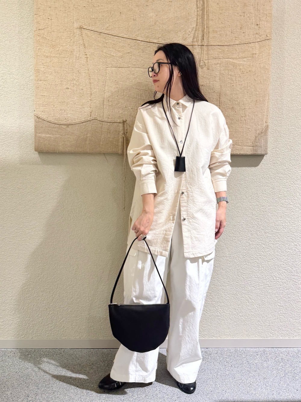 ホワイト系のその他アウター、ホワイト系のその他パンツ、ブラック系のハンドバッグを着用したレディースの春コーディネートの1枚目の写真