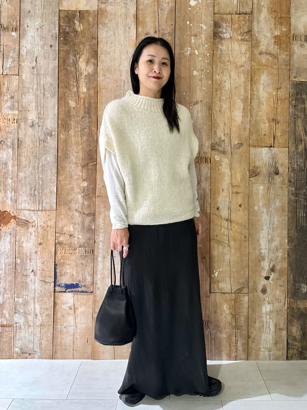 ホワイト系のTシャツ/カットソー、ホワイト系のニット/セーター、グレー系のスカートを着用したレディースの秋コーディネートの1枚目の写真