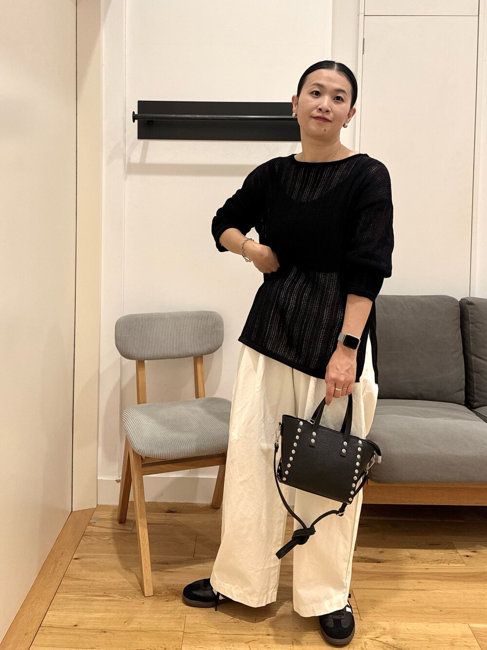 ブラック系のニット/セーター、ホワイト系のその他パンツ、ブラック系のショルダーバッグを着用したレディースの秋コーディネートの1枚目の写真