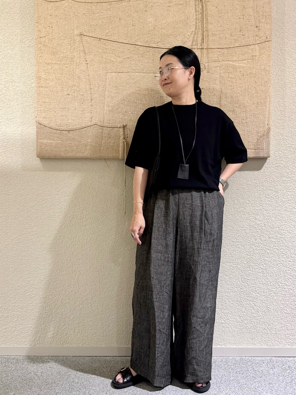 ブラック系のニット/セーター、ブラック系のパンツ、ブラック系のハンドバッグを着用したレディースの春コーディネートの1枚目の写真