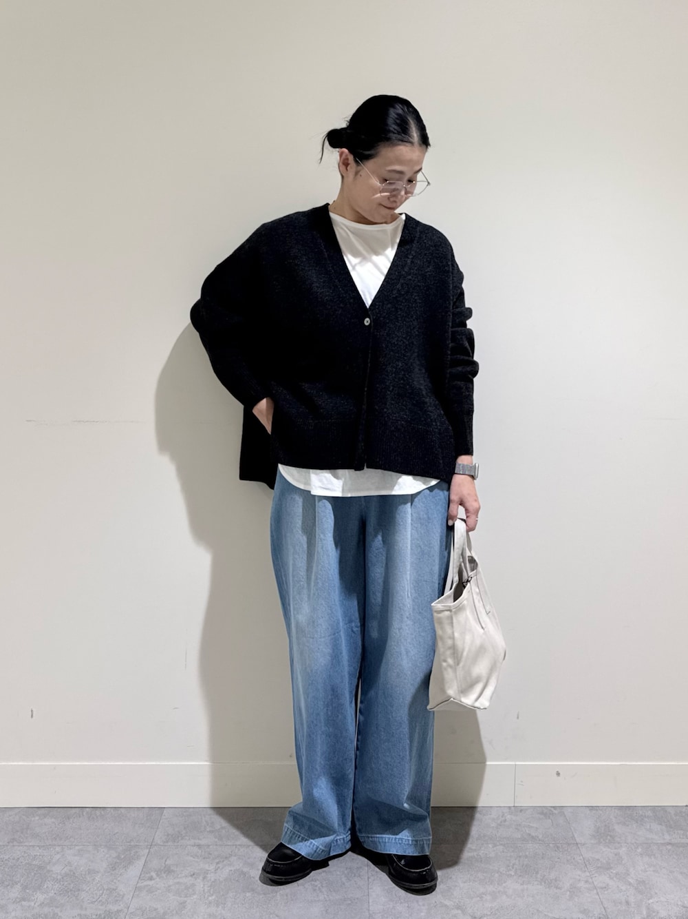 グレー系のカーディガン/ボレロ、ホワイト系のTシャツ/カットソー、ブルー系のデニムパンツを着用したレディースの冬コーディネートの1枚目の写真