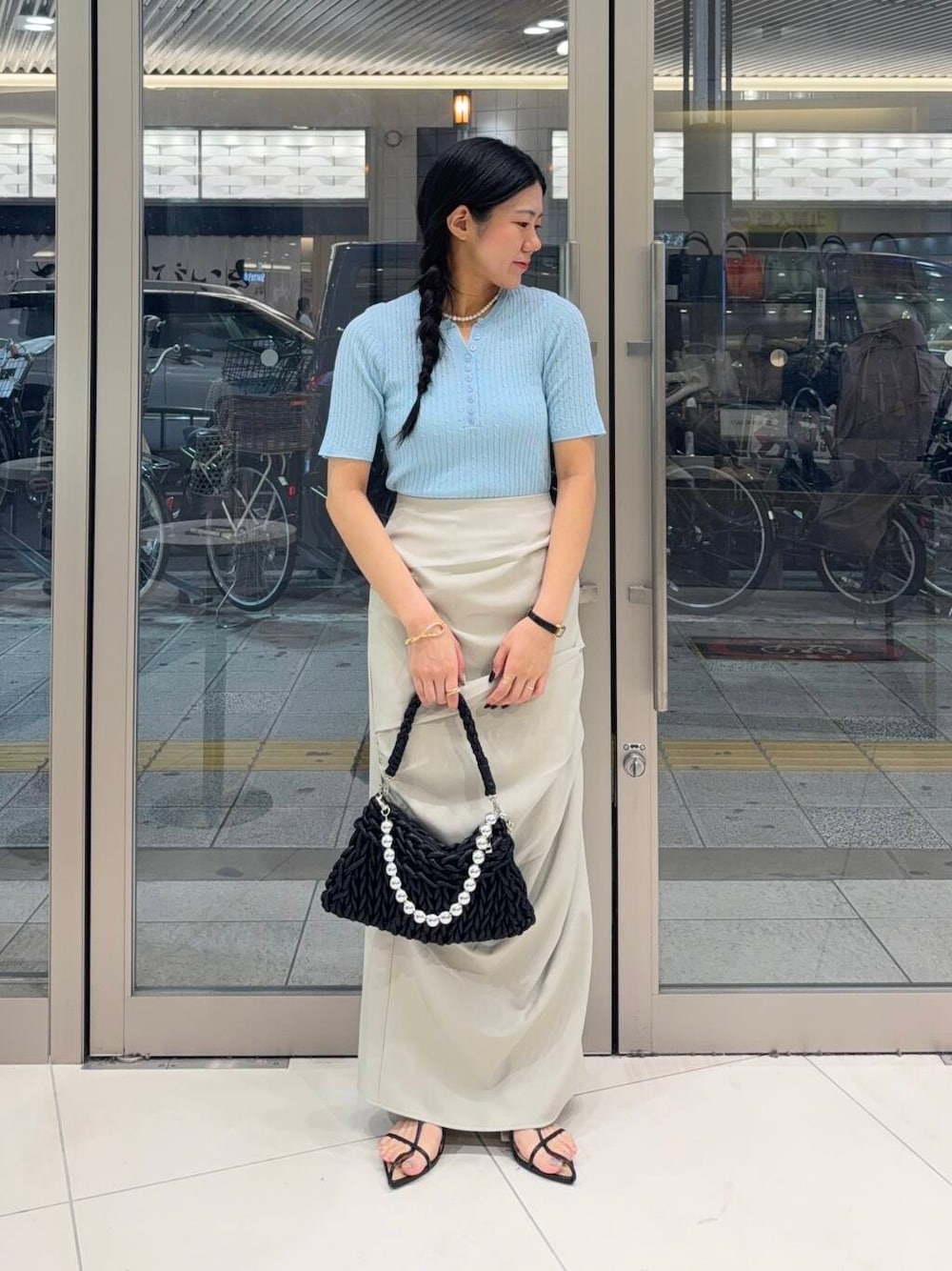 ブラック系のハンドバッグ、ホワイト系のキャミソール、ブラック系のサンダルを着用したレディースの夏コーディネートの1枚目の写真