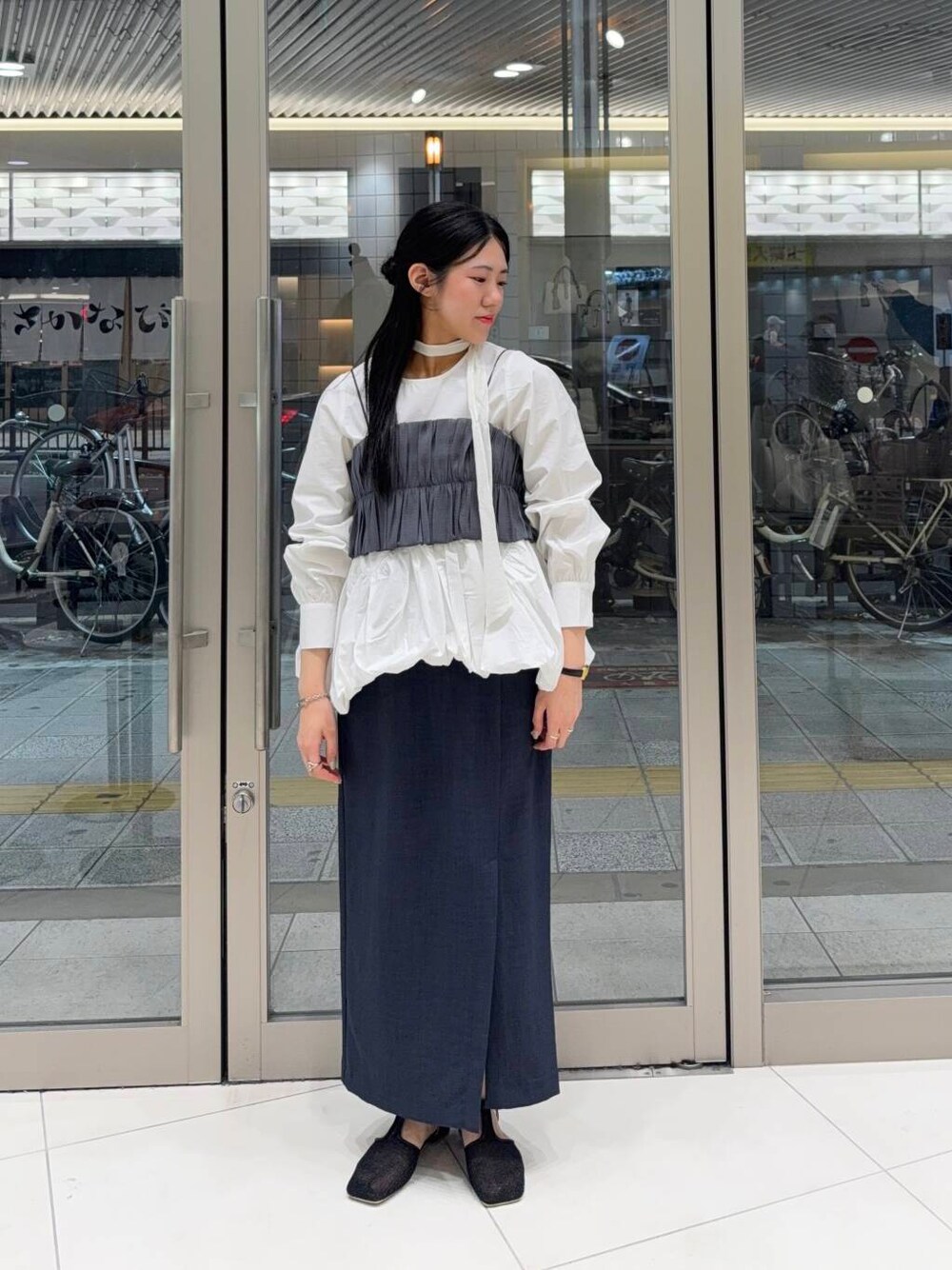 ブラック系のパンプス、ホワイト系のシャツ/ブラウス、グレー系のワンピースを着用したレディースの春コーディネートの1枚目の写真