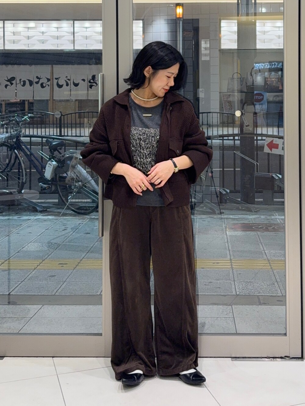 ブラウン系のその他アウター、ブラウン系のその他パンツ、ブラック系のニット/セーターを着用したレディースの秋コーディネートの1枚目の写真