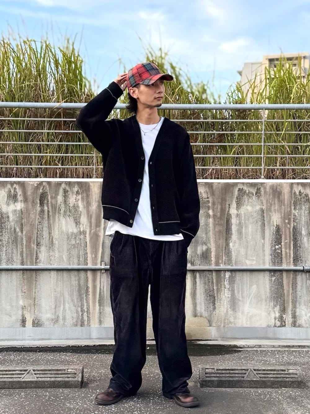 レッド系のキャップを着用したメンズの秋コーディネートの1枚目の写真