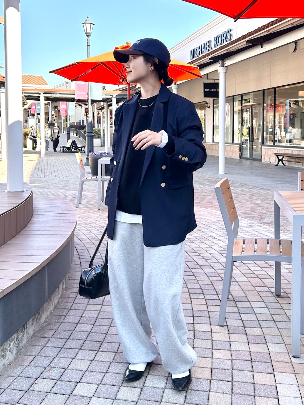 ブラック系のニット/セーター、ブルー系のテーラードジャケット、ブラック系のパンプスを着用したレディースの冬コーディネートの1枚目の写真