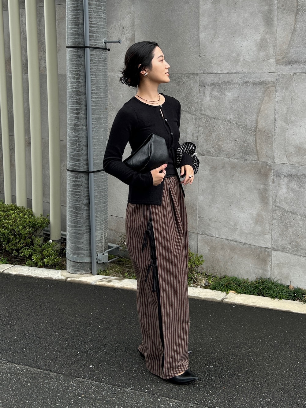 ブラウン系のその他パンツ、ブラック系のTシャツ/カットソー、ブラック系のハンドバッグを着用したレディースの春コーディネートの1枚目の写真