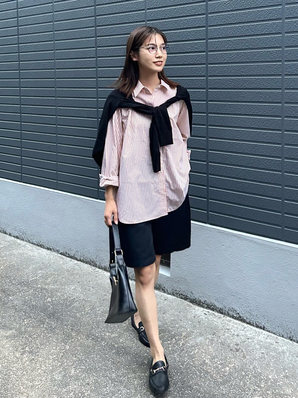 ブラック系のカーディガン/ボレロ、ブラック系のチノパンツ、ブラック系のハンドバッグを着用したレディースの秋コーディネートの1枚目の写真